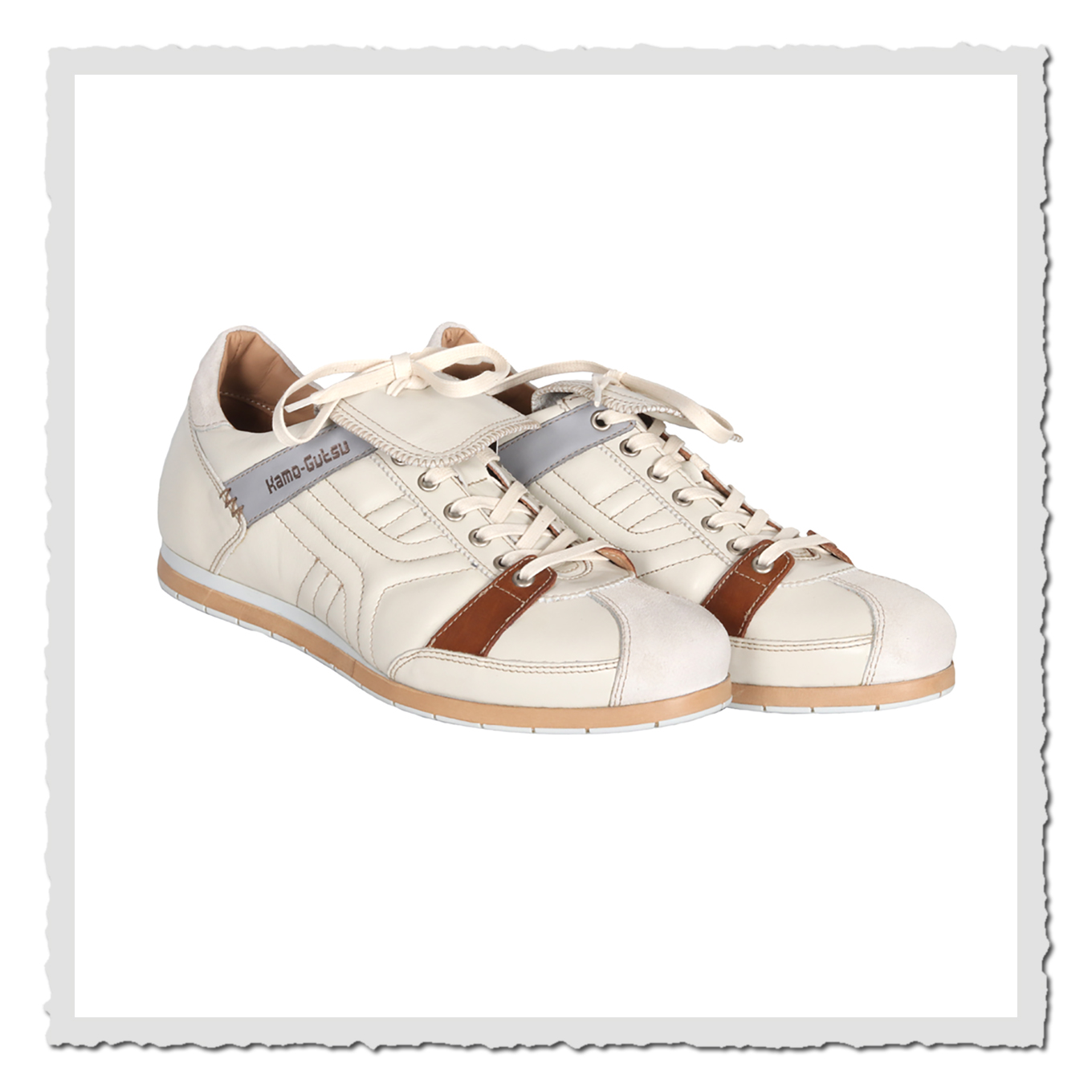 Zwei altweiße Freizeitschuhe in schräger Vorderansicht, freigestellt vor hellem Hintergrund mit heller Schnürung.